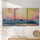 Three-panel canvas wall art featuring prismatic watercolor coastal seascape, displayed in a minimalist living room above a console table.
