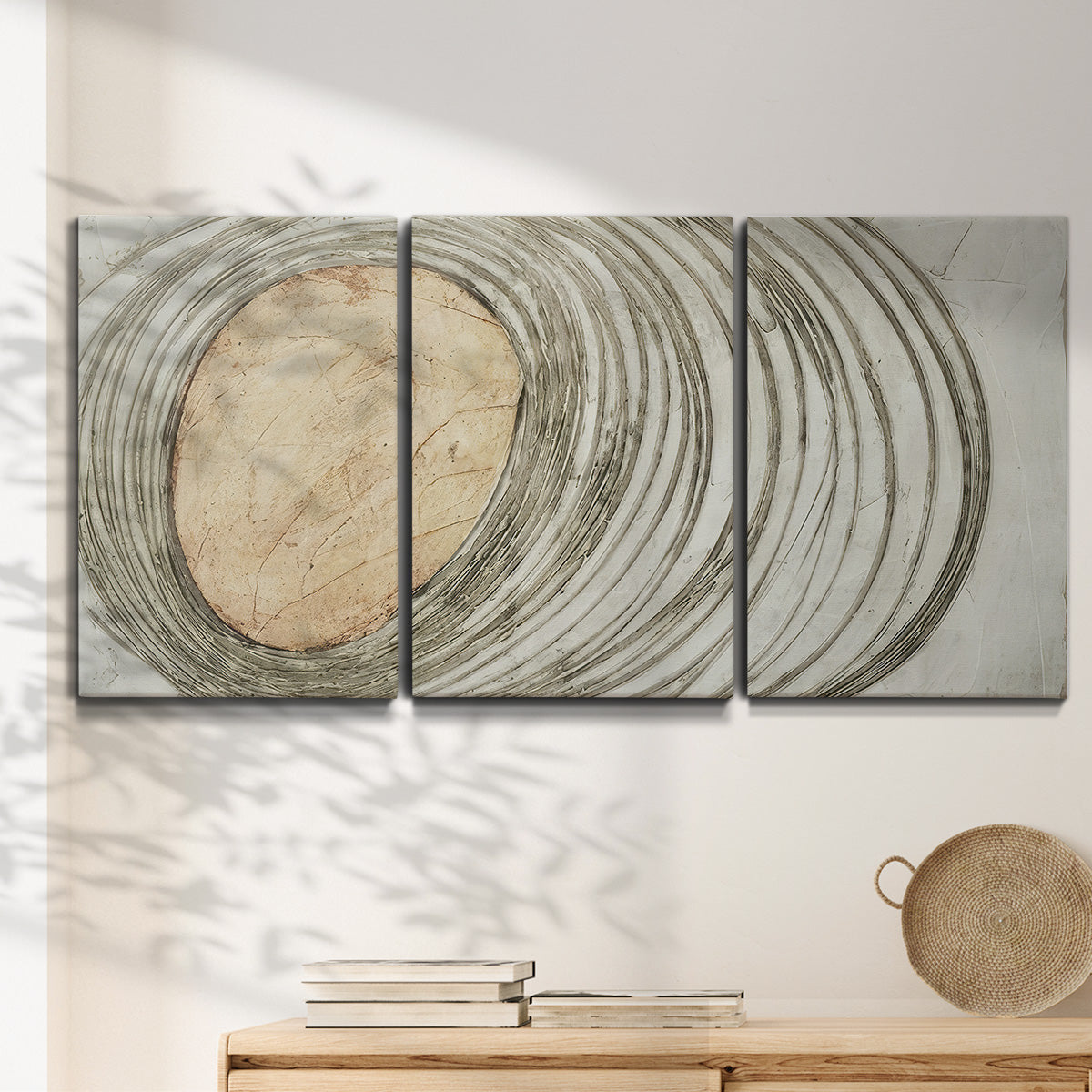 Three-panel canvas wall art featuring circular abstract energy forms, displayed in a minimalist living room above a console table.