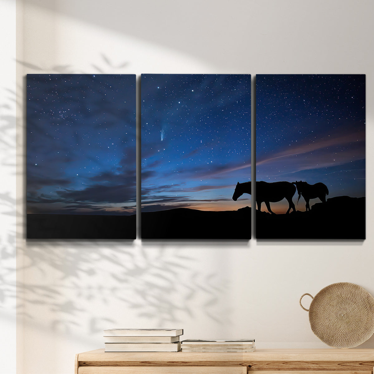 Three-panel canvas wall art featuring resting animals in open field, displayed in a minimalist living room above a console table.