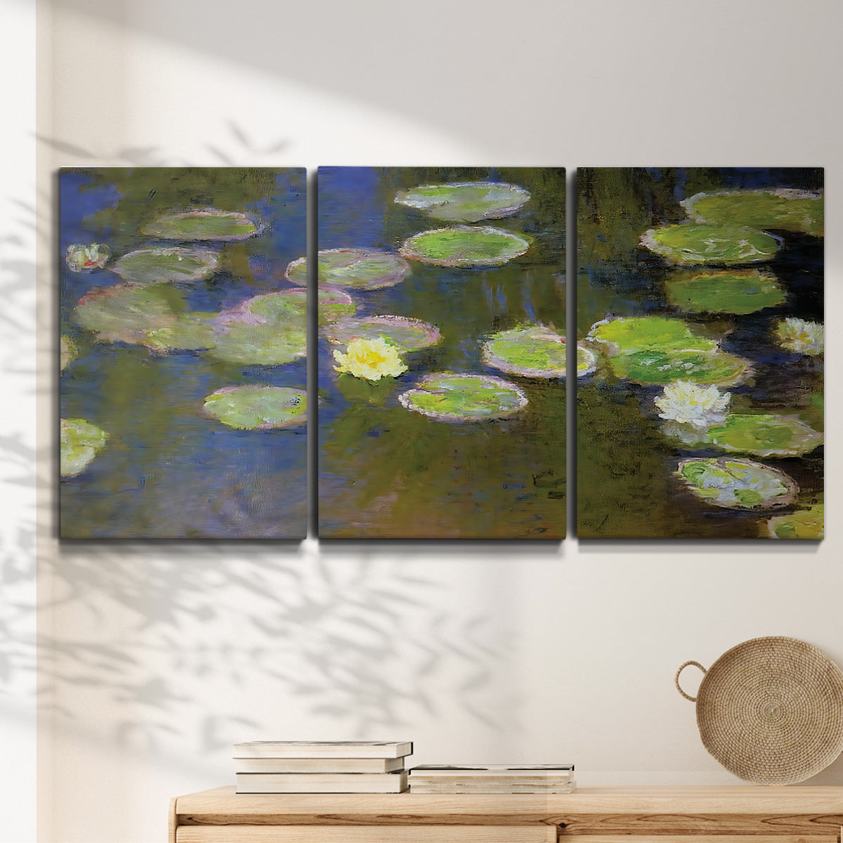 Three-panel canvas wall art featuring yellow and white water lilies, displayed in a minimalist living room above a console table.