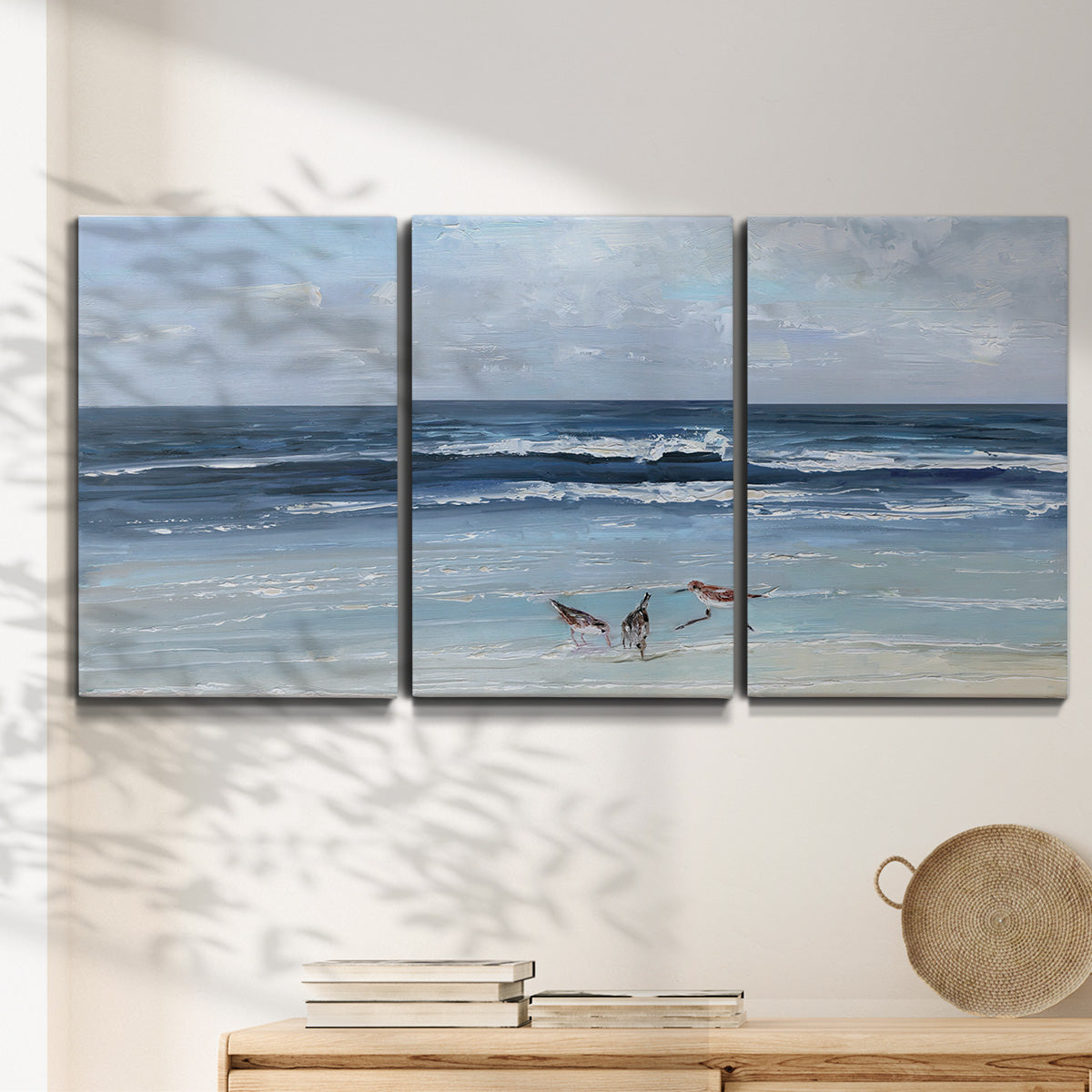 Three-panel canvas wall art featuring loose farmhouse style floral painting, displayed in a minimalist living room above a console table.