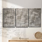 Three-panel canvas wall art featuring grid based geometric abstraction, displayed in a minimalist living room above a console table.