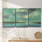 Three-panel canvas wall art featuring still lagoon water beneath open sky, displayed in a minimalist living room above a console table.