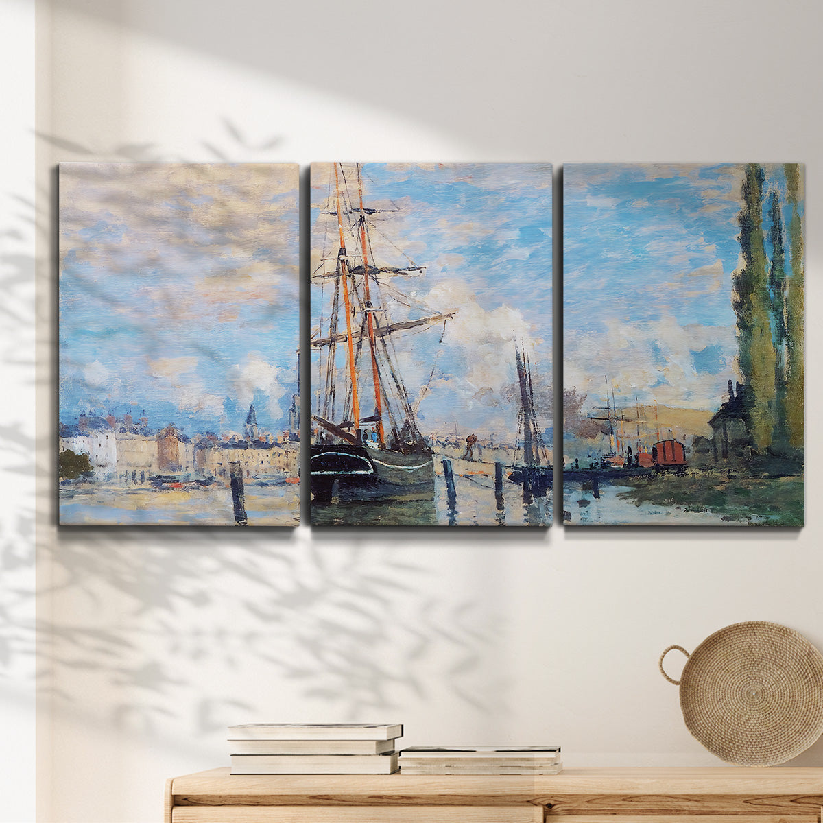Three-panel canvas wall art featuring busy river port scene, displayed in a minimalist living room above a console table.