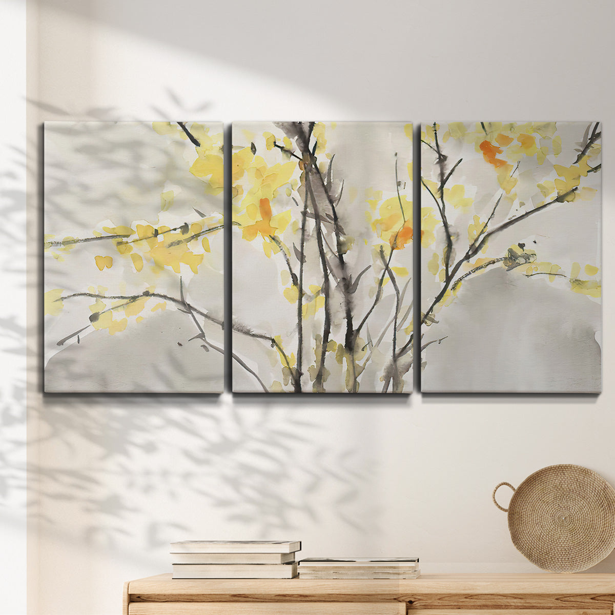 Three-panel canvas wall art featuring soft floral abstract harmony, displayed in a minimalist living room above a console table.