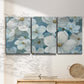 Three-panel canvas wall art featuring soft white floral abstraction, displayed in a minimalist living room above a console table.