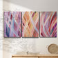 Three-panel canvas wall art featuring layered modern abstract color ribbons, displayed in a minimalist living room above a console table.
