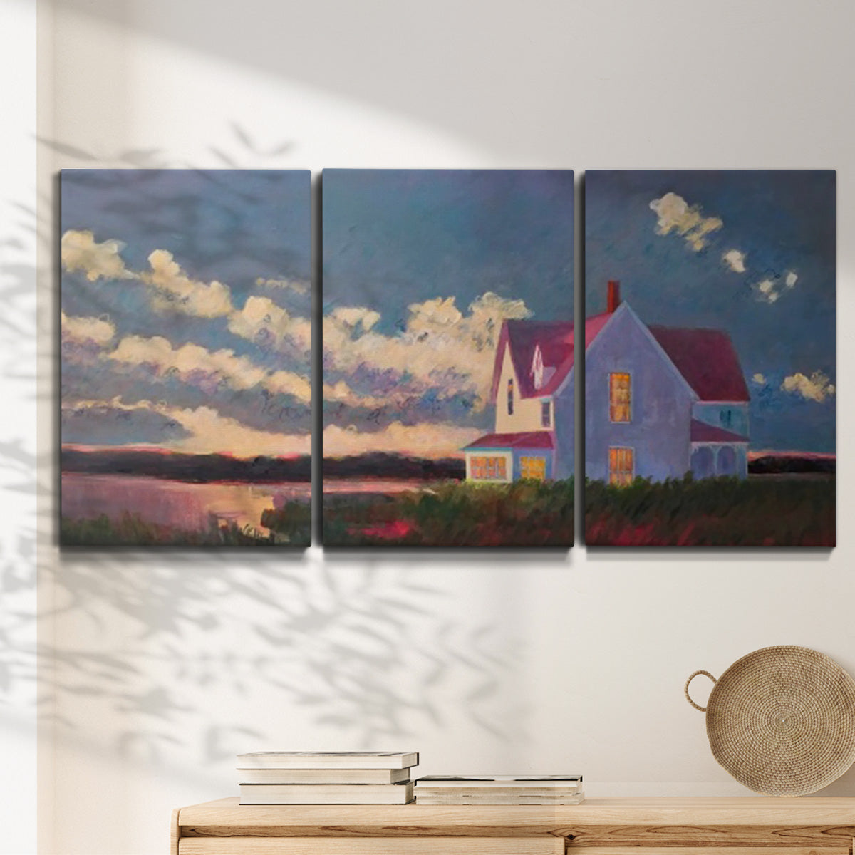 Three-panel canvas wall art featuring farmhouse scene before approaching storm, displayed in a minimalist living room above a console table.