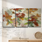 Three-panel canvas wall art featuring layered floral botanical impressions, displayed in a minimalist living room above a console table.