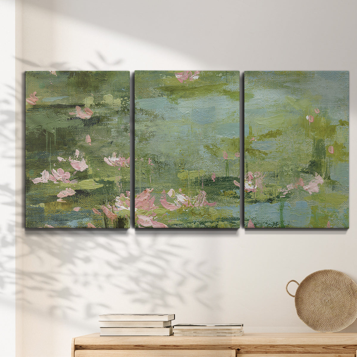 Three-panel canvas wall art featuring muted water lily pond, displayed in a minimalist living room above a console table.