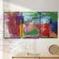 Three-panel canvas wall art featuring vibrant abstract color field panels, displayed in a minimalist living room above a console table.