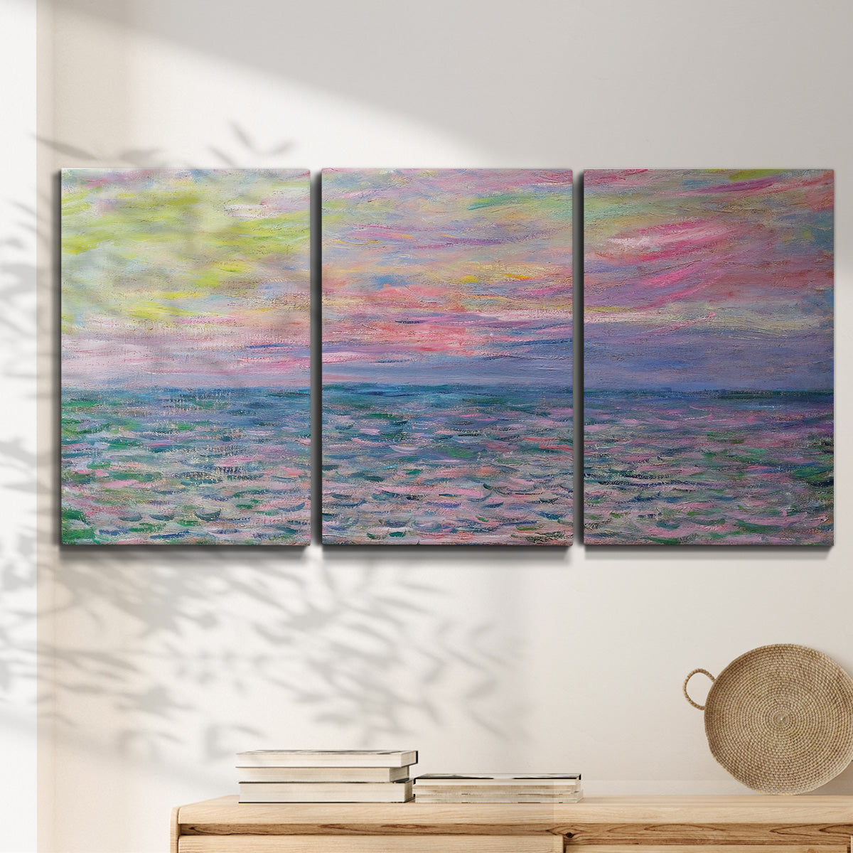 Three-panel canvas wall art featuring sunset reflections across calm sea, displayed in a minimalist living room above a console table.