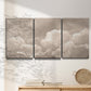 Three-panel canvas wall art featuring soft whimsical cloudscape, displayed in a minimalist living room above a console table.