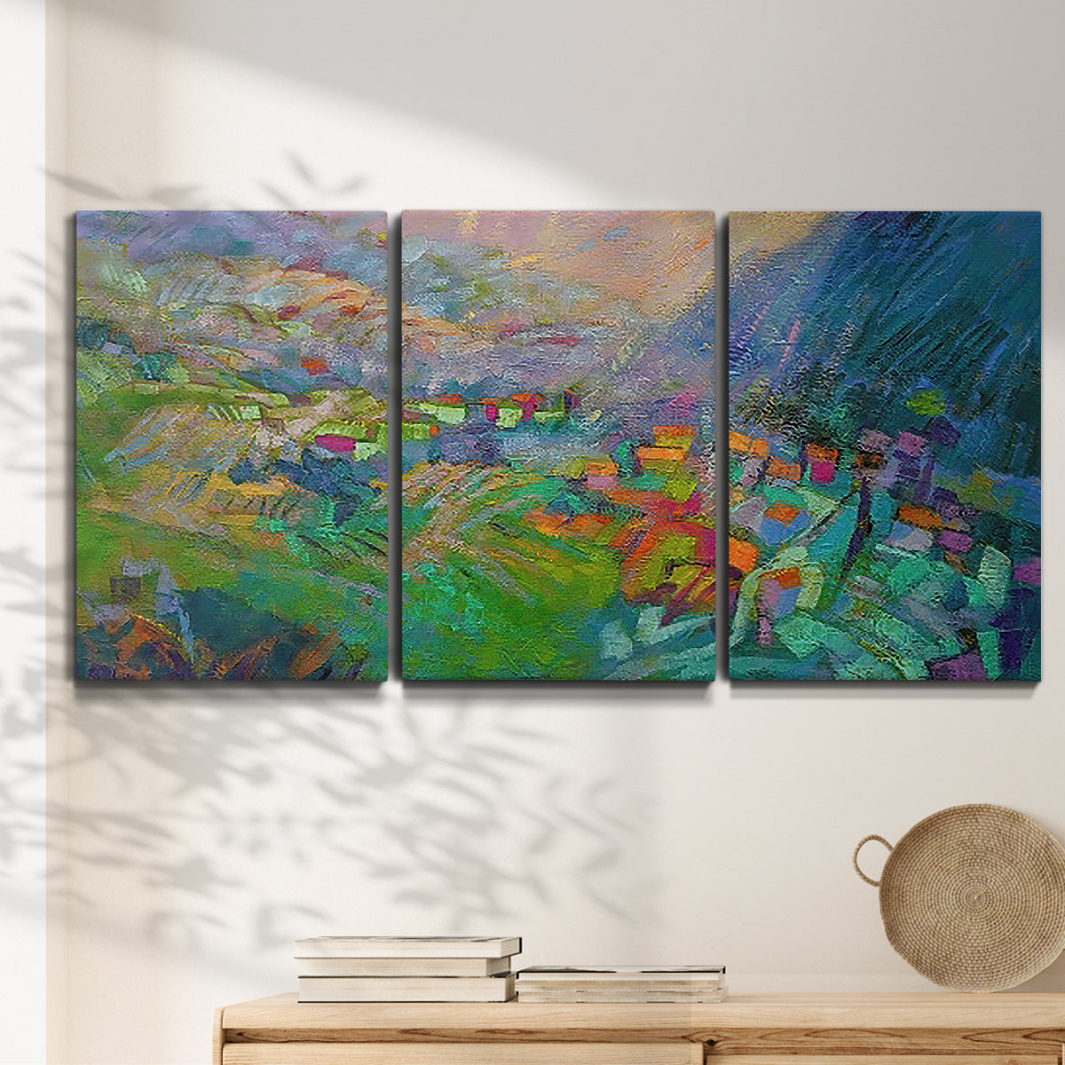 Three-panel canvas wall art featuring embracing landscape with warm tones, displayed in a minimalist living room above a console table.