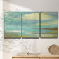 Three-panel canvas wall art featuring calm coastal drift patterns, displayed in a minimalist living room above a console table.