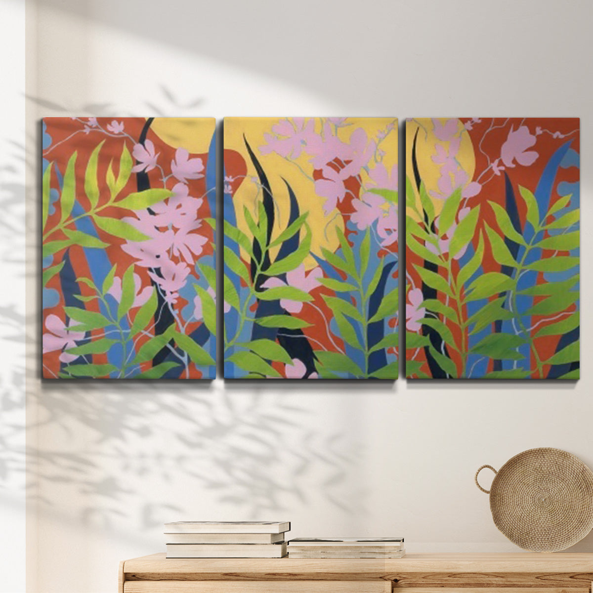 Three-panel canvas wall art featuring bold colorful floral abstraction, displayed in a minimalist living room above a console table.