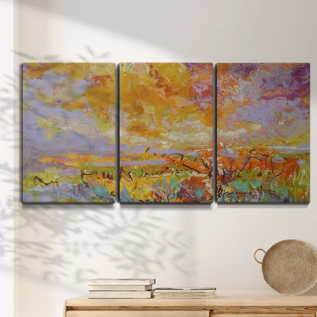 Three-panel canvas wall art featuring abstract meadow inspired color fields, displayed in a minimalist living room above a console table.