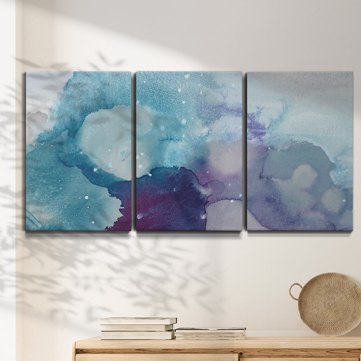 Three-panel canvas wall art featuring icy abstract crystalline forms, displayed in a minimalist living room above a console table.