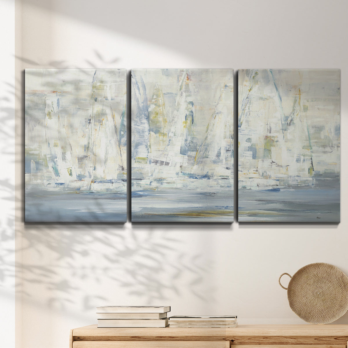 Three-panel canvas wall art featuring impressionist regatta scene with sailboats, displayed in a minimalist living room above a console table.