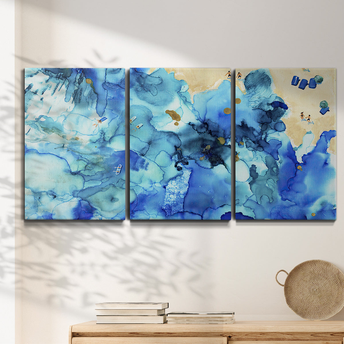 Three-panel canvas wall art featuring abstract coastal beach color fields, displayed in a minimalist living room above a console table.