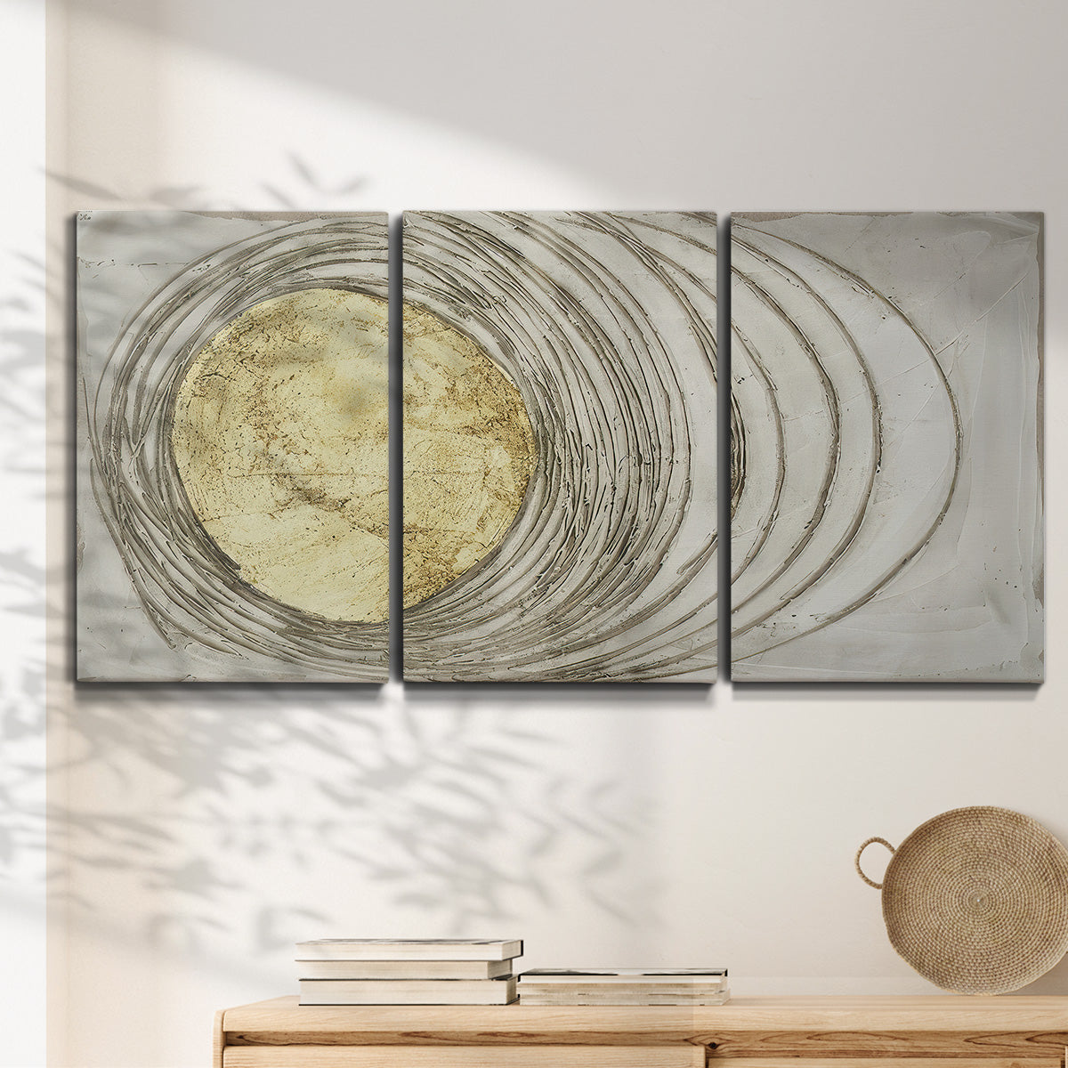 Three-panel canvas wall art featuring circular abstract energy forms, displayed in a minimalist living room above a console table.