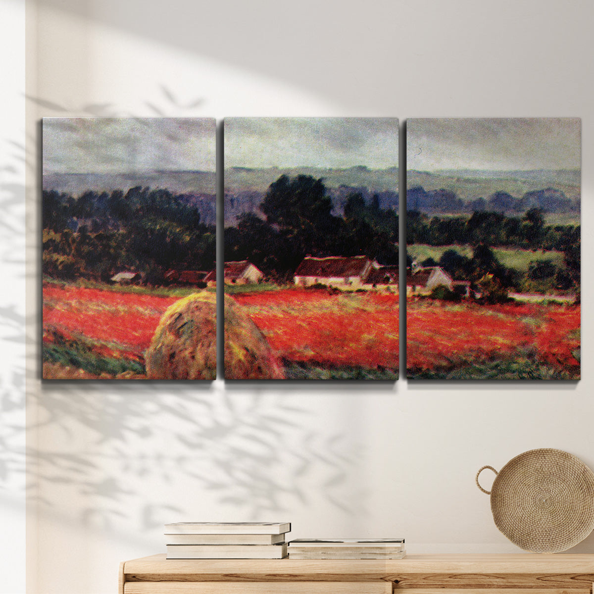 Three-panel canvas wall art featuring red poppy field near barn, displayed in a minimalist living room above a console table.