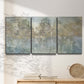 Three-panel canvas wall art featuring abstract river reflections, displayed in a minimalist living room above a console table.