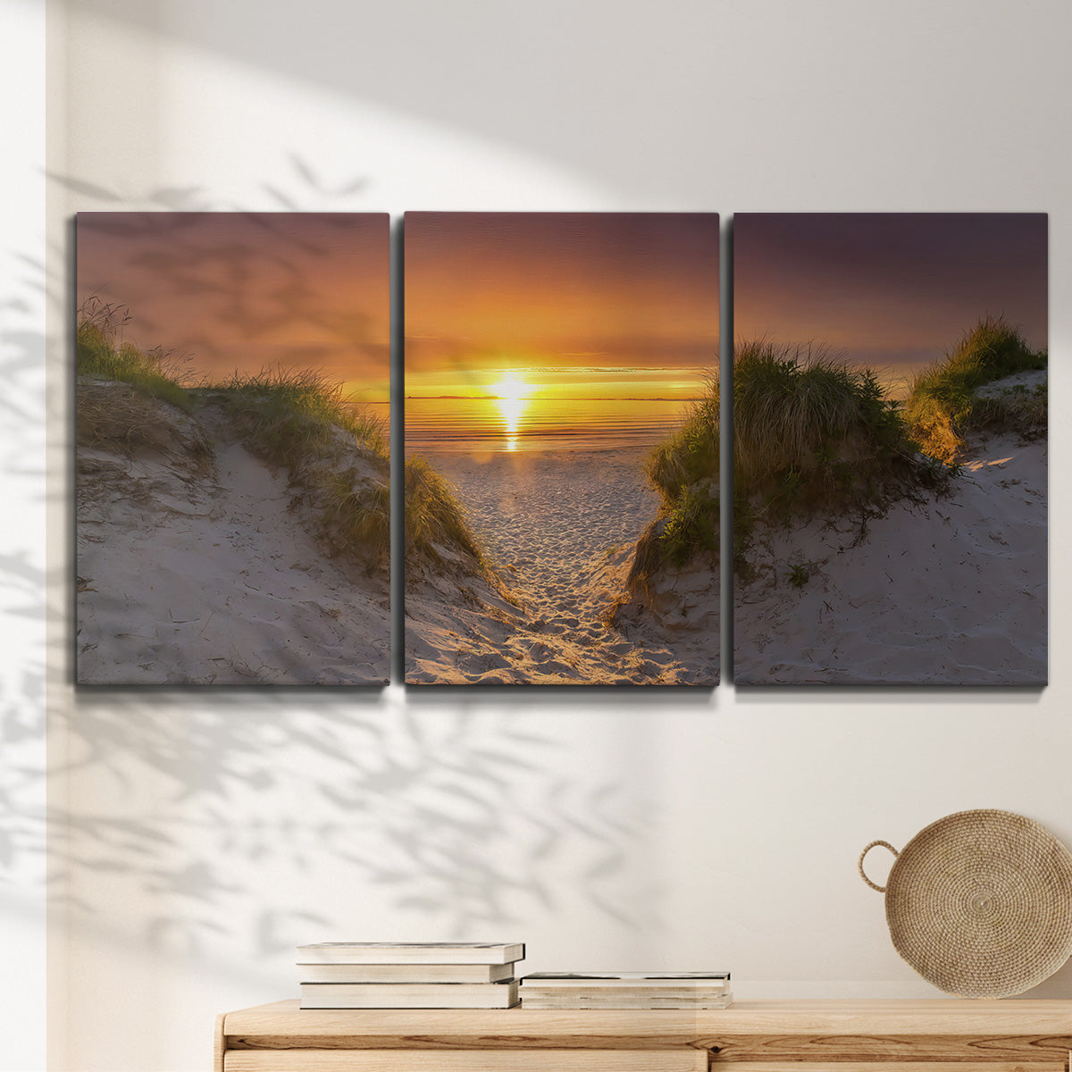 Three-panel canvas wall art featuring sunlit tropical path through greenery, displayed in a minimalist living room above a console table.