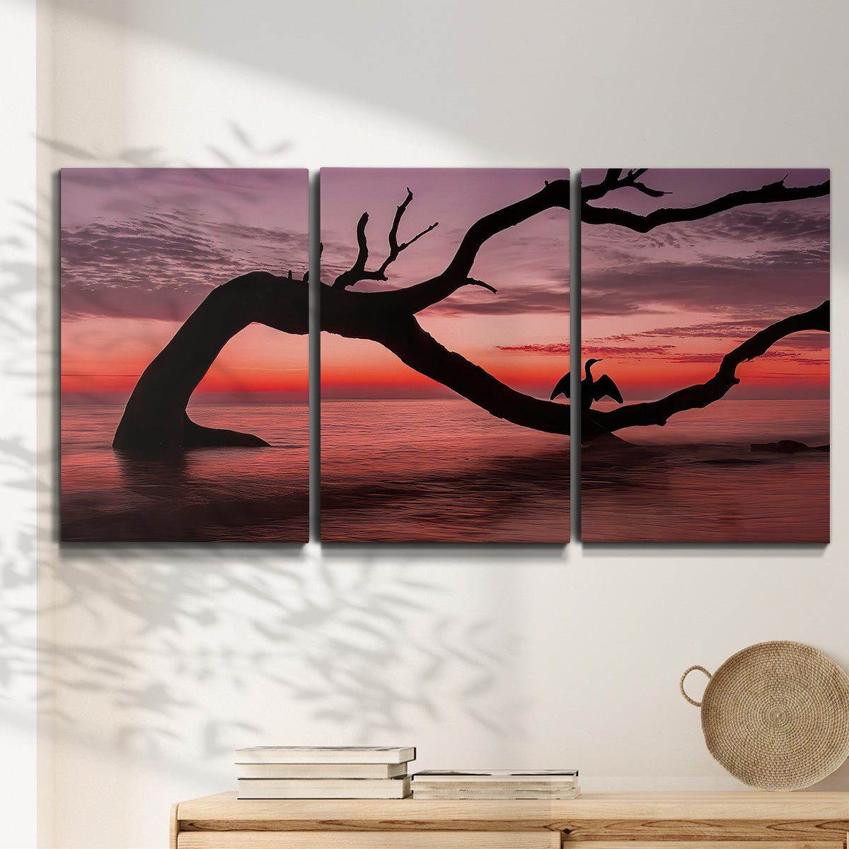Three-panel canvas wall art featuring sunset beach photography, displayed in a minimalist living room above a console table.