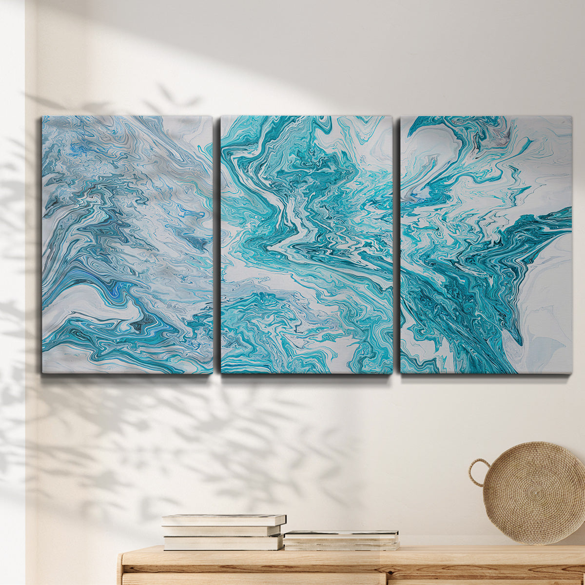 Three-panel canvas wall art featuring rocky coastal tide pool scene, displayed in a minimalist living room above a console table.
