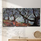 Three-panel canvas wall art featuring pine trees silhouetted at evening, displayed in a minimalist living room above a console table.