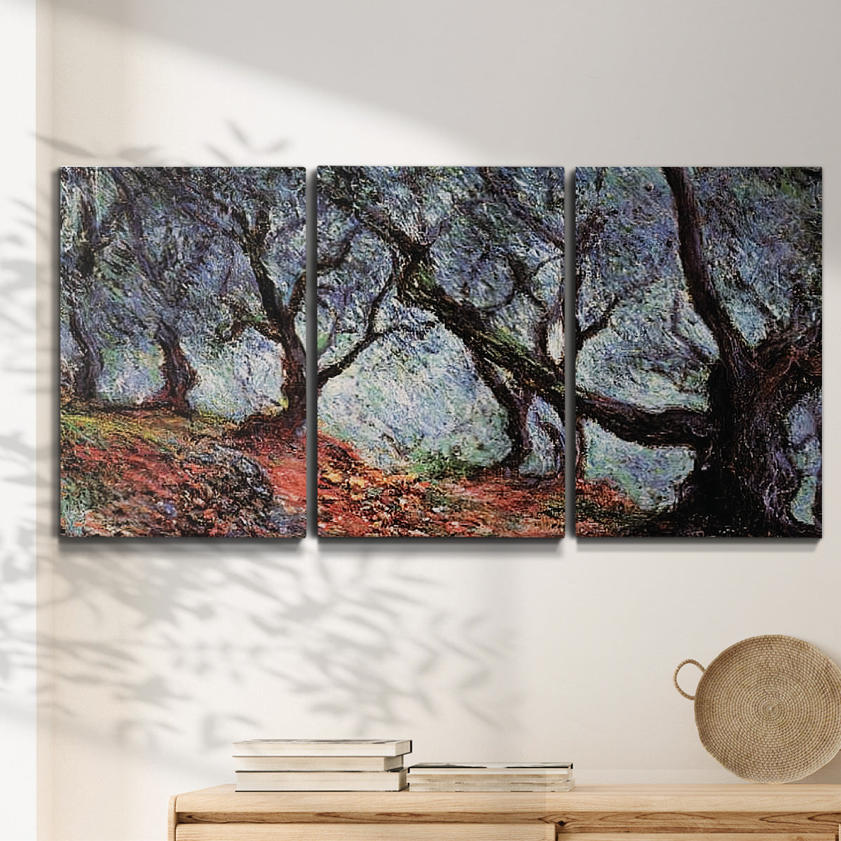 Three-panel canvas wall art featuring pine trees silhouetted at evening, displayed in a minimalist living room above a console table.