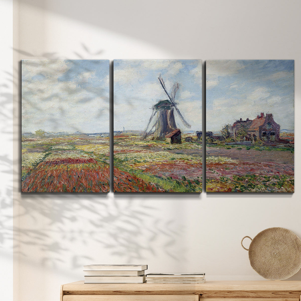 Three-panel canvas wall art featuring tulip fields with windmill, displayed in a minimalist living room above a console table.