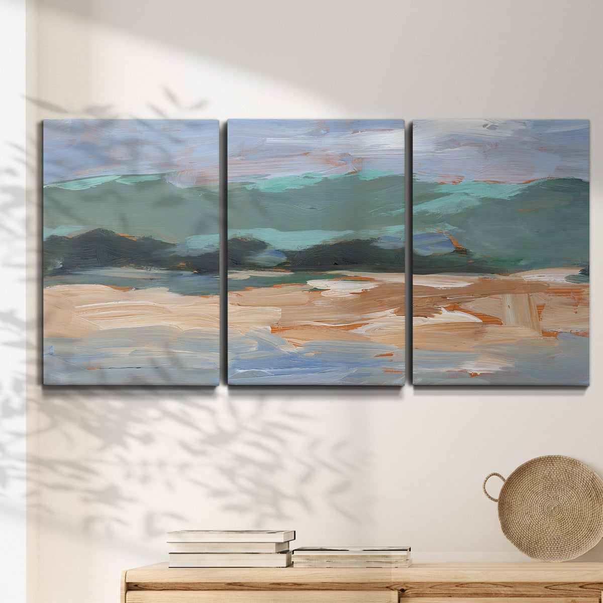 Three-panel canvas wall art featuring abstract landscape composition study, displayed in a minimalist living room above a console table.