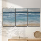 Three-panel canvas wall art featuring rolling ocean waves near shore, displayed in a minimalist living room above a console table.