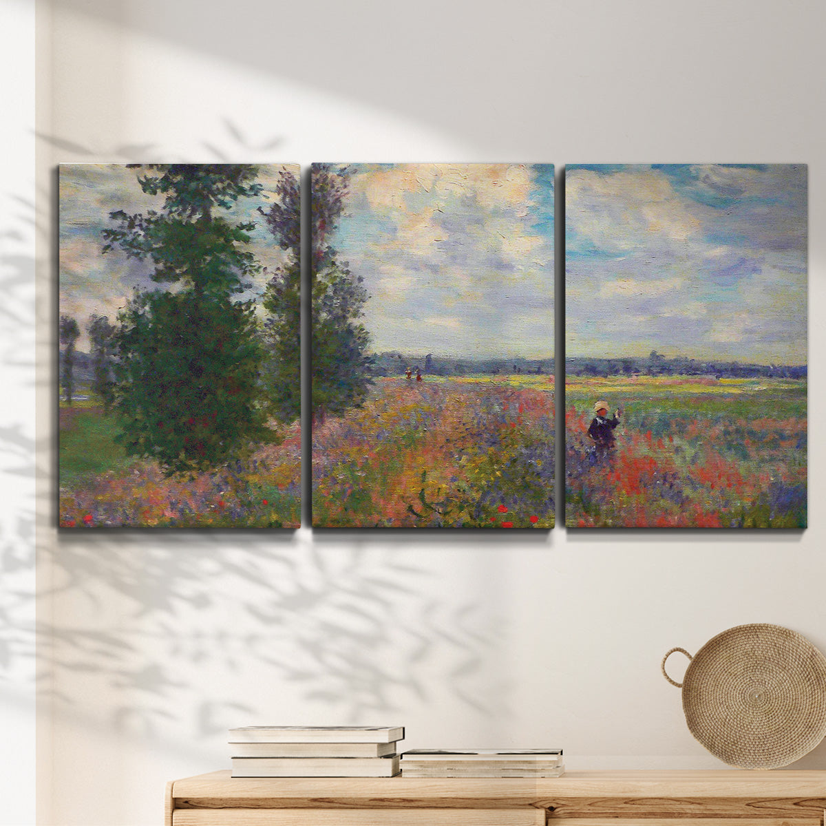 Three-panel canvas wall art featuring poppy field in open countryside, displayed in a minimalist living room above a console table.