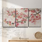 Three-panel canvas wall art featuring blooming cherry blossom branches, displayed in a minimalist living room above a console table.