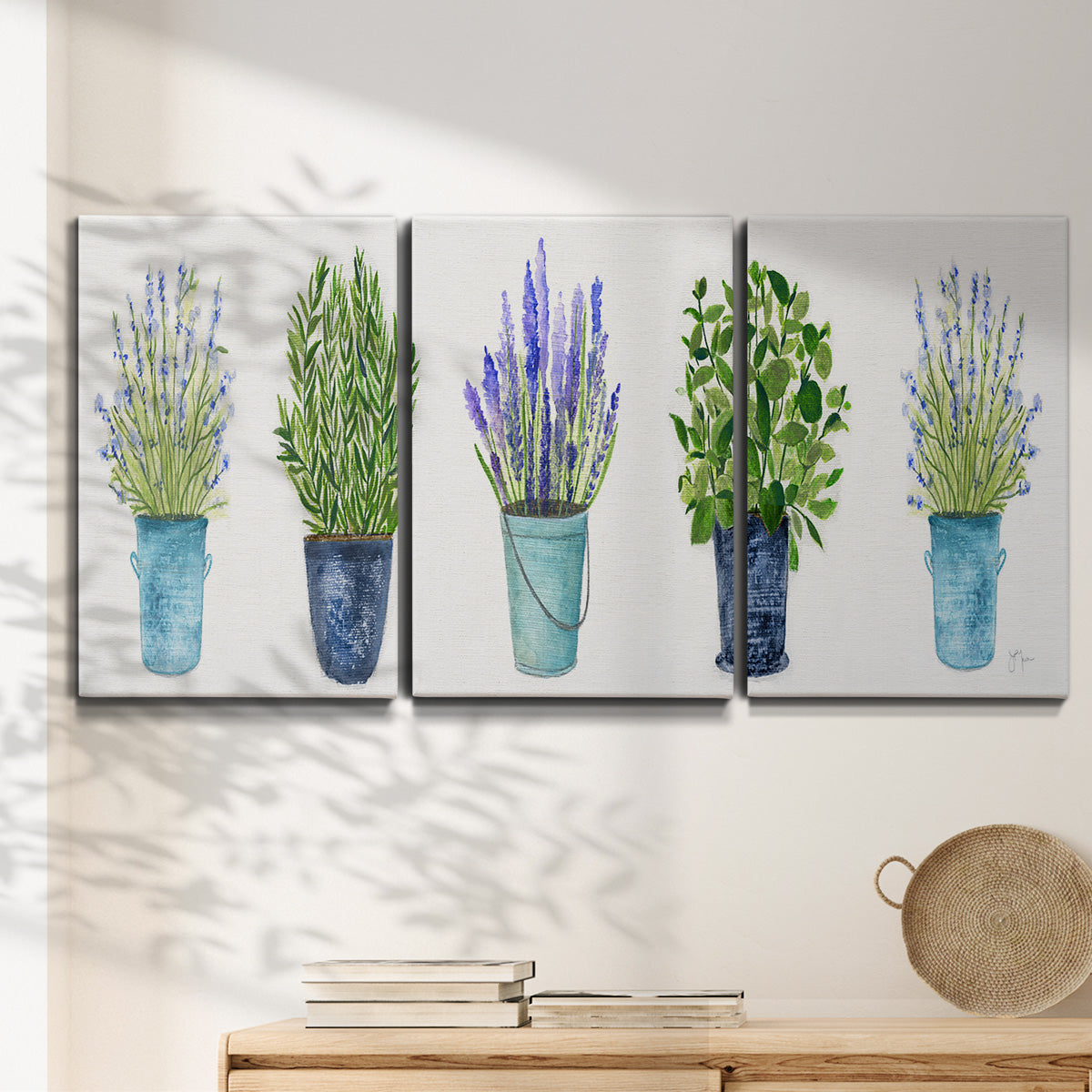 Three-panel canvas wall art featuring minimal monochrome abstract forms, displayed in a minimalist living room above a console table.