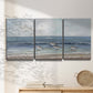 Three-panel canvas wall art featuring shore birds searching along beach, displayed in a minimalist living room above a console table.