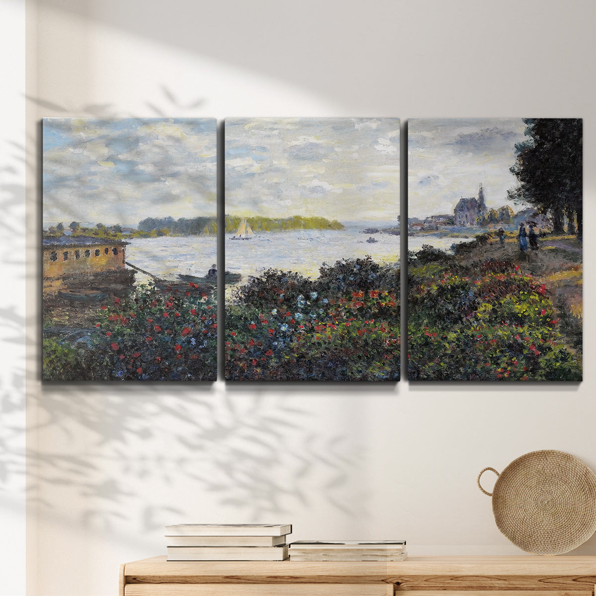 Three-panel canvas wall art featuring river with boats and shoreline, displayed in a minimalist living room above a console table.