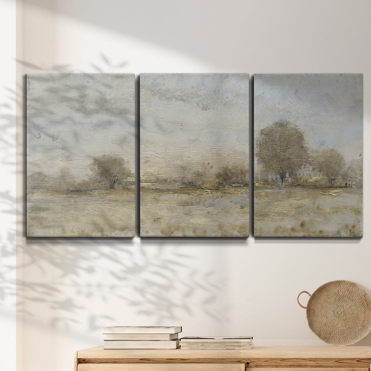 Three-panel canvas wall art featuring late season rural harvest fields, displayed in a minimalist living room above a console table.