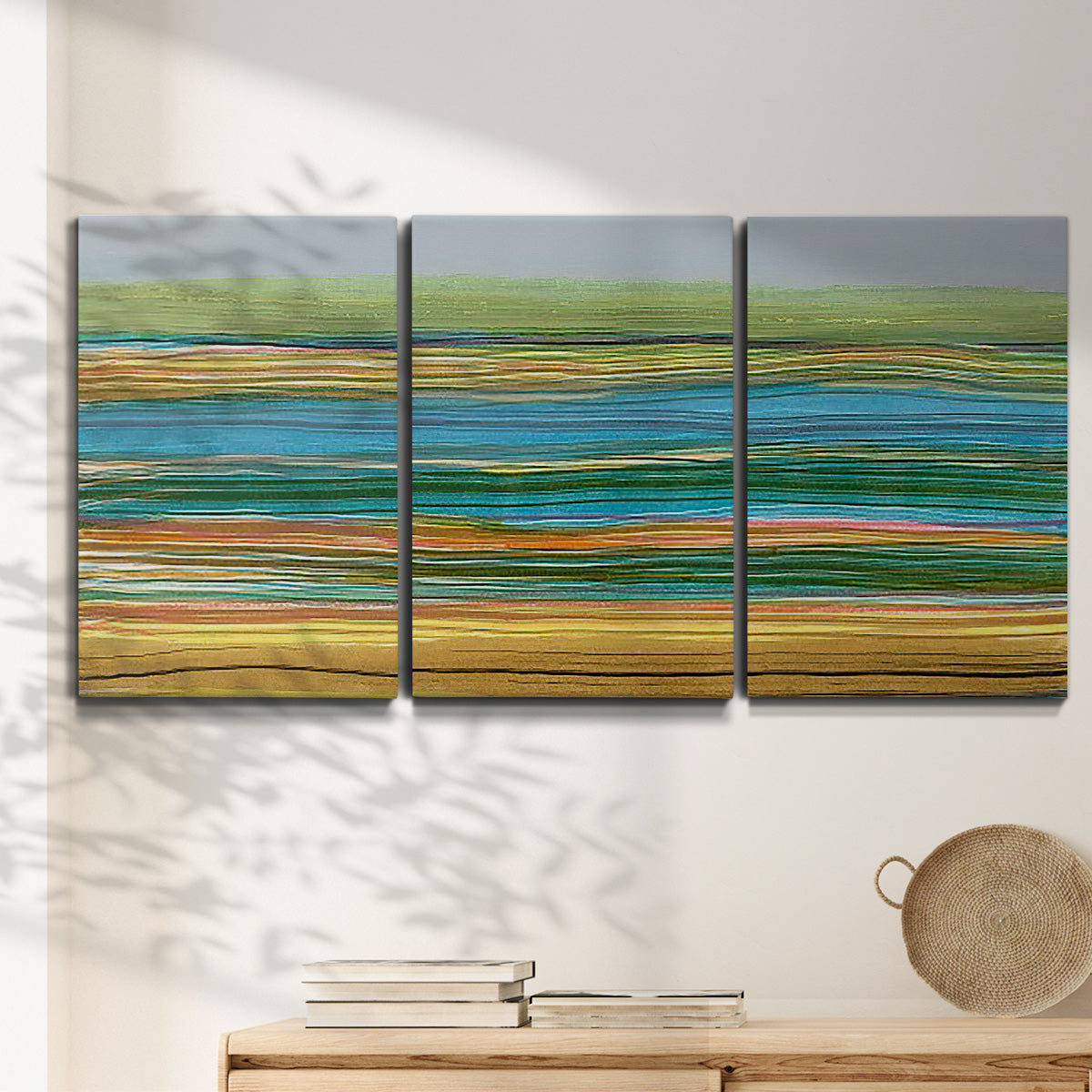 Three-panel canvas wall art featuring parallel linear abstract striations, displayed in a minimalist living room above a console table.