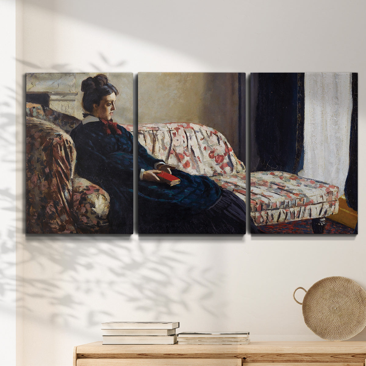 Three-panel canvas wall art featuring woman resting on sofa indoors, displayed in a minimalist living room above a console table.