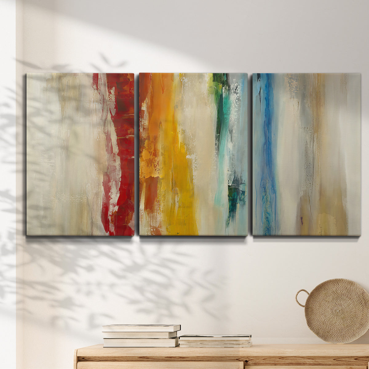 Three-panel canvas wall art featuring abstract divided color hemisphere forms, displayed in a minimalist living room above a console table.