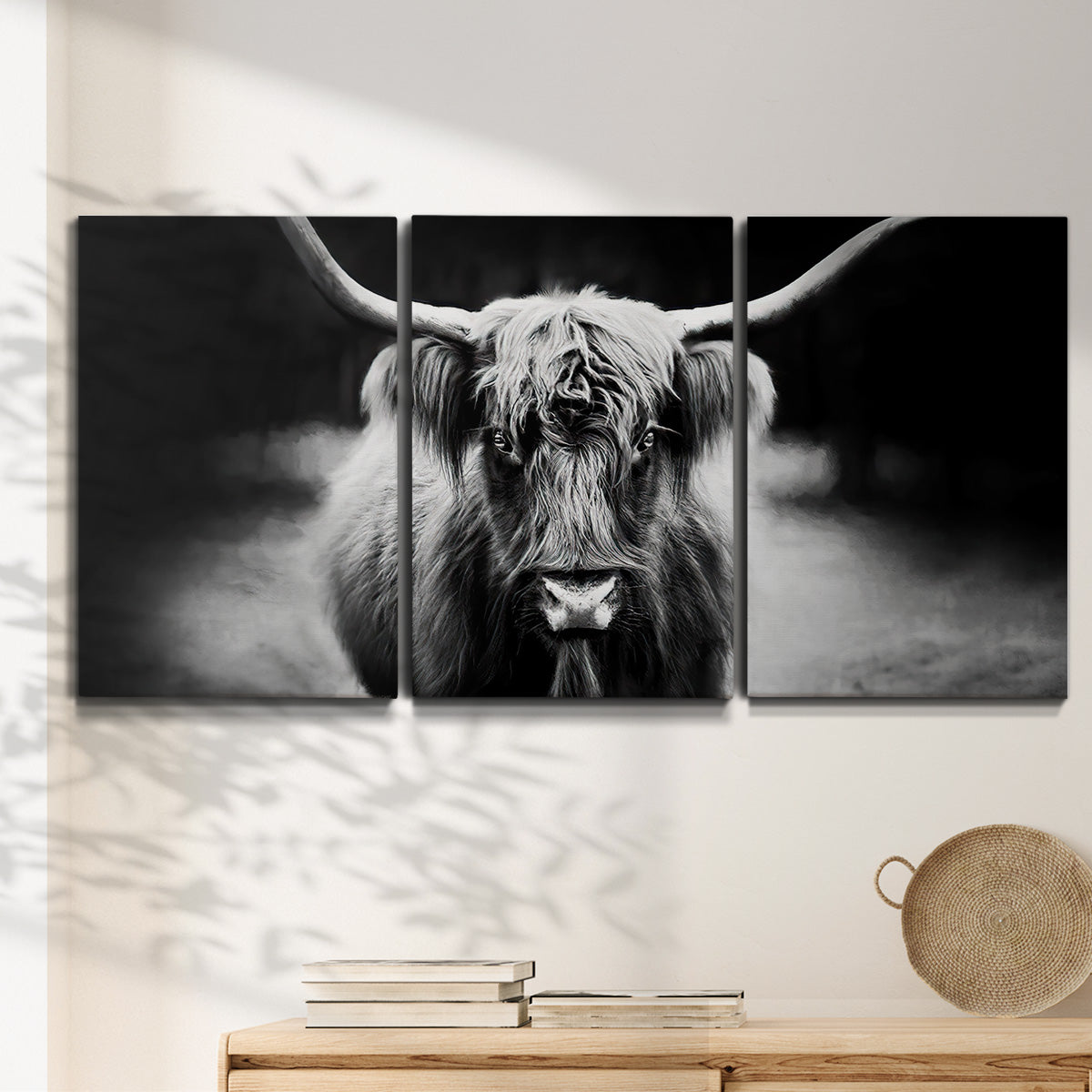 Three-panel canvas wall art featuring black and white cattle portrait, displayed in a minimalist living room above a console table.