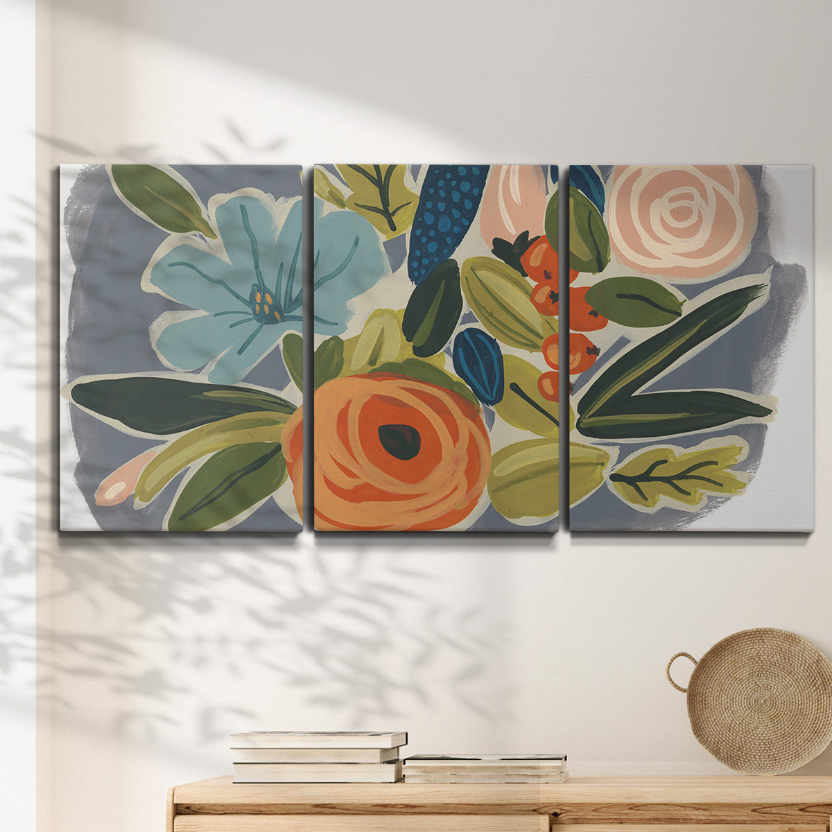 Three-panel canvas wall art featuring colorful botanical illustration, displayed in a minimalist living room above a console table.