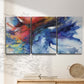 Three-panel canvas wall art featuring vibrant abstract color explosion, displayed in a minimalist living room above a console table.