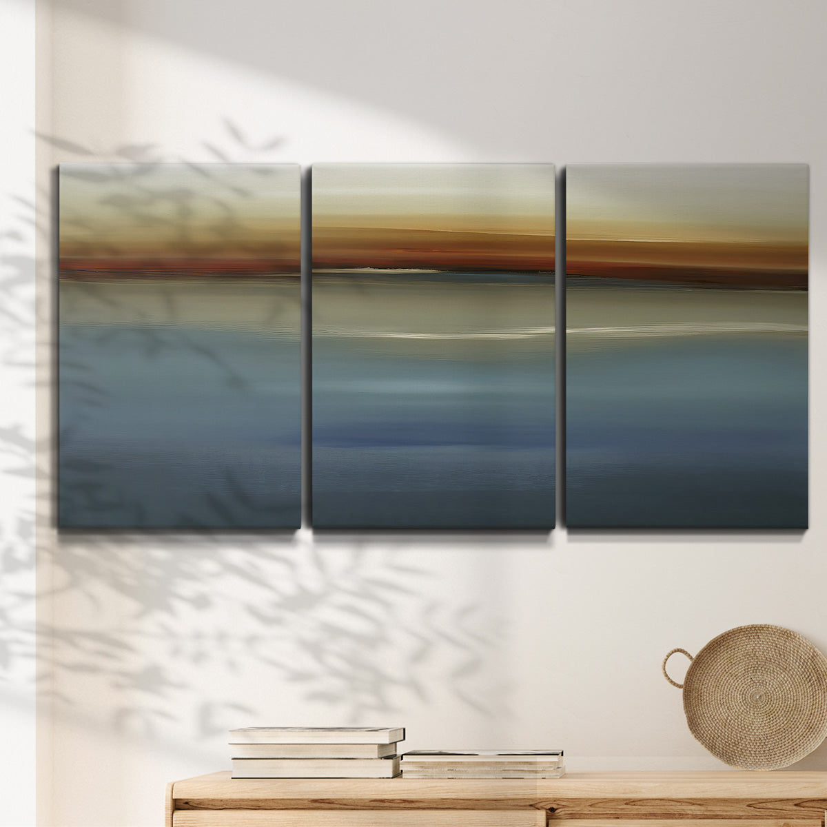 Three-panel canvas wall art featuring horizontal abstract coastal color bands, displayed in a minimalist living room above a console table.