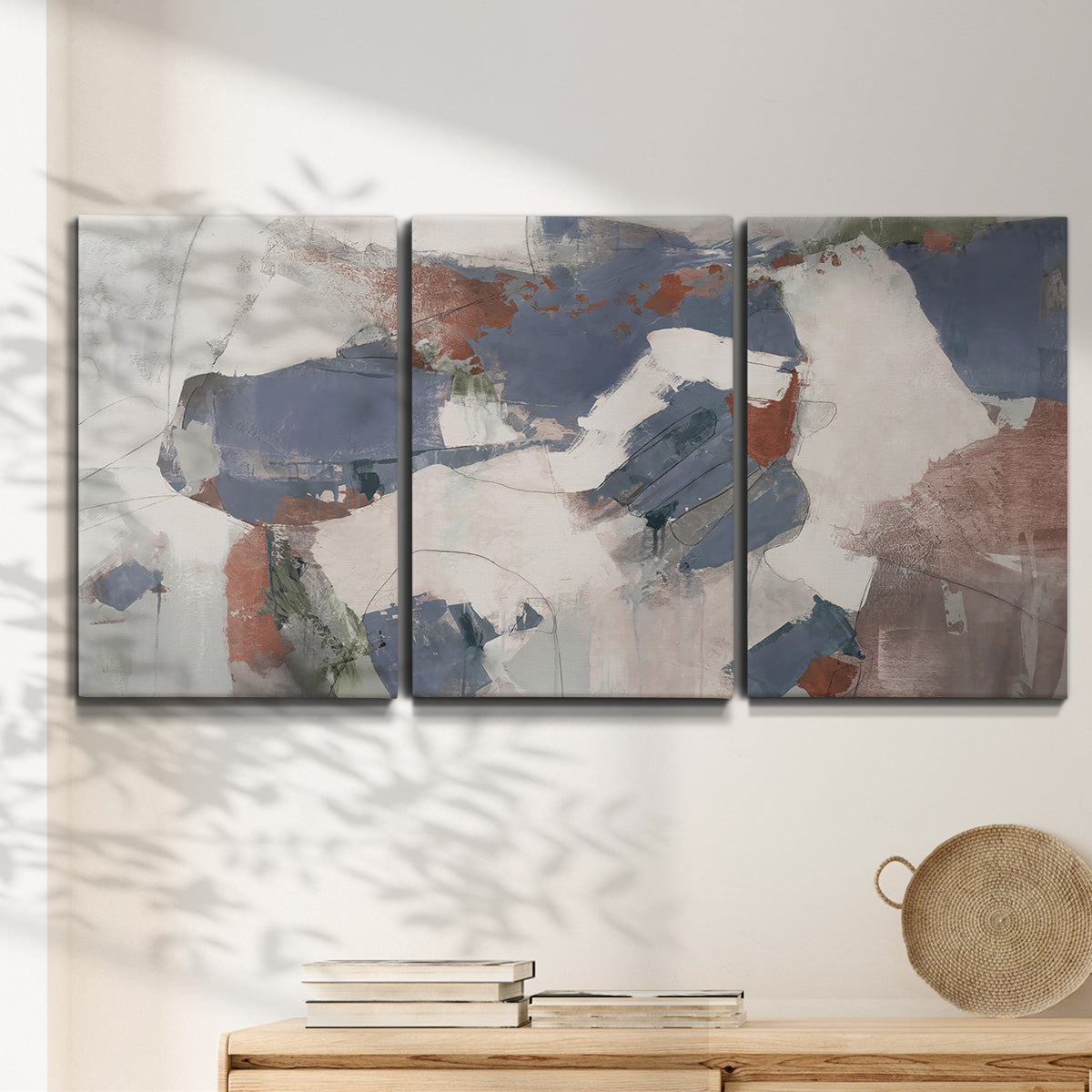 Three-panel canvas wall art featuring cool blue abstract layered composition, displayed in a minimalist living room above a console table.