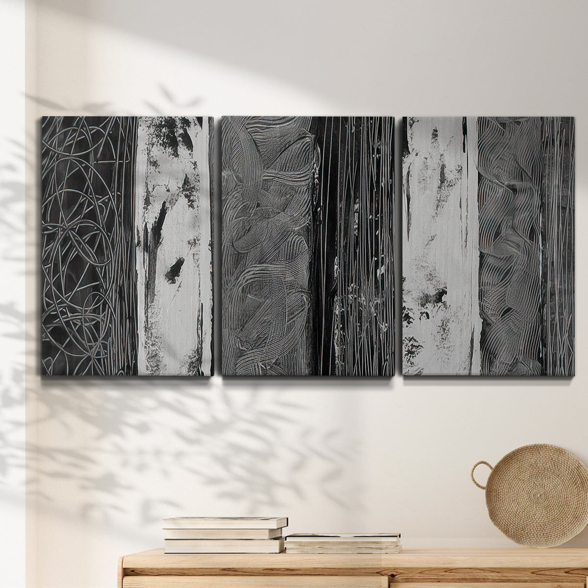 Three-panel canvas wall art featuring brushed metallic abstract textures, displayed in a minimalist living room above a console table.